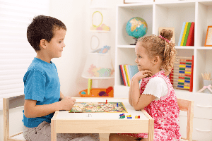 Two children playing a board game together at Kid's Country
