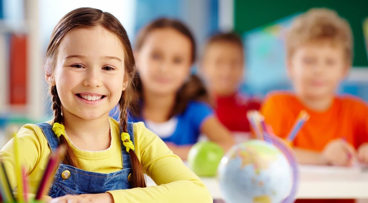 A smiling student in a Kid's Country classroom